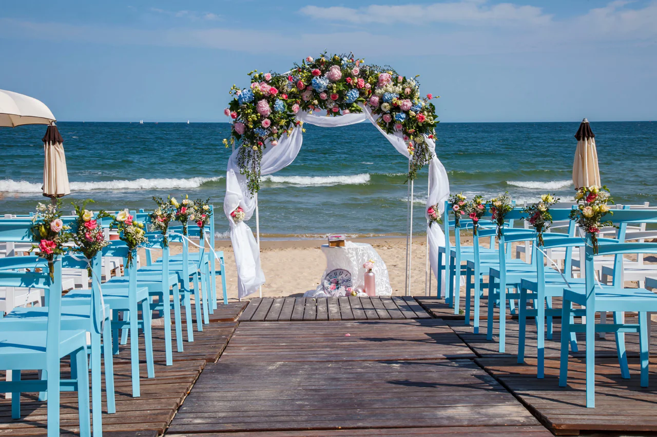 bruiloft op het strand met blauwe stoelen.